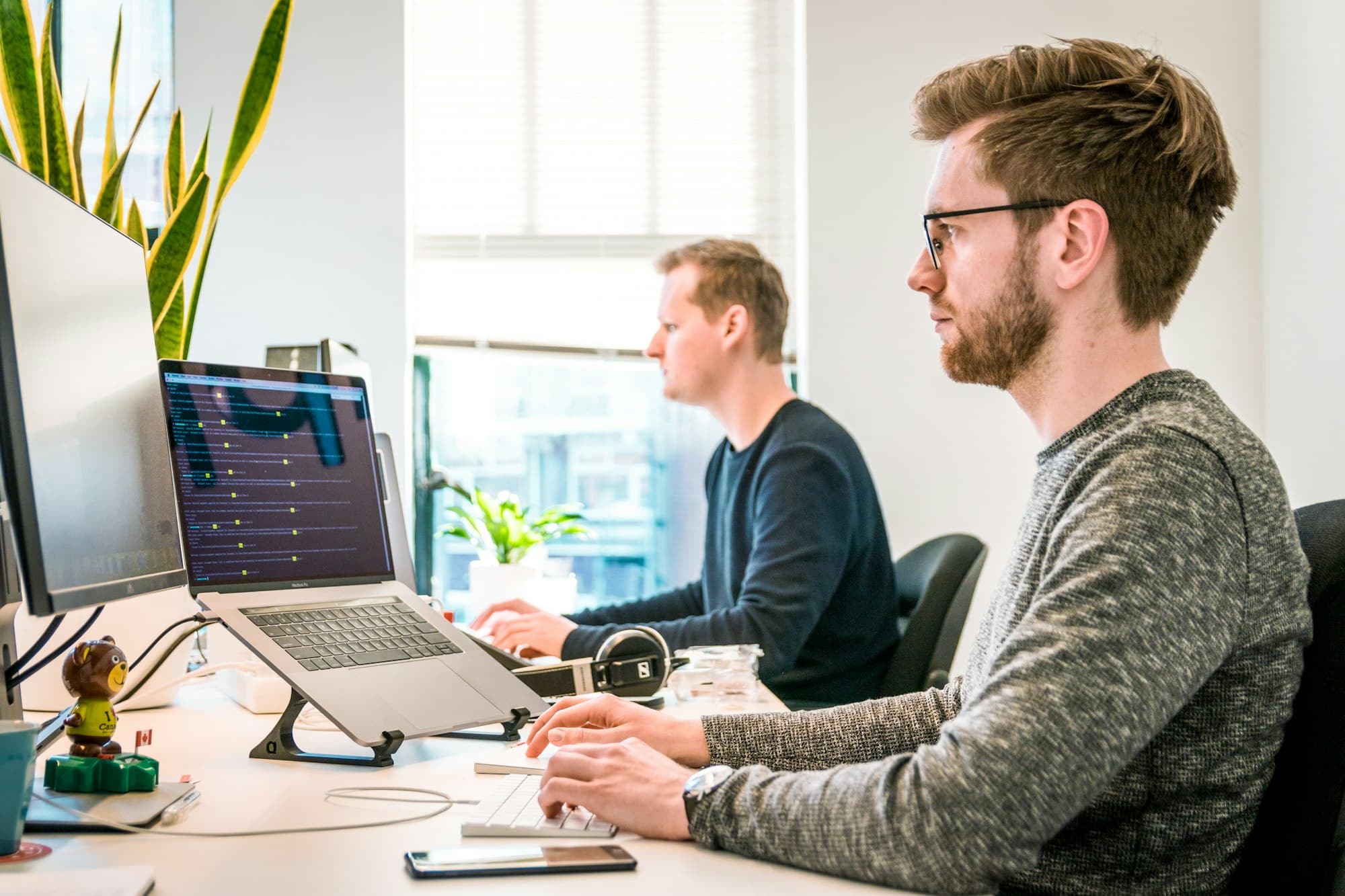 Engineers working at their desks in an open, naturally lit office