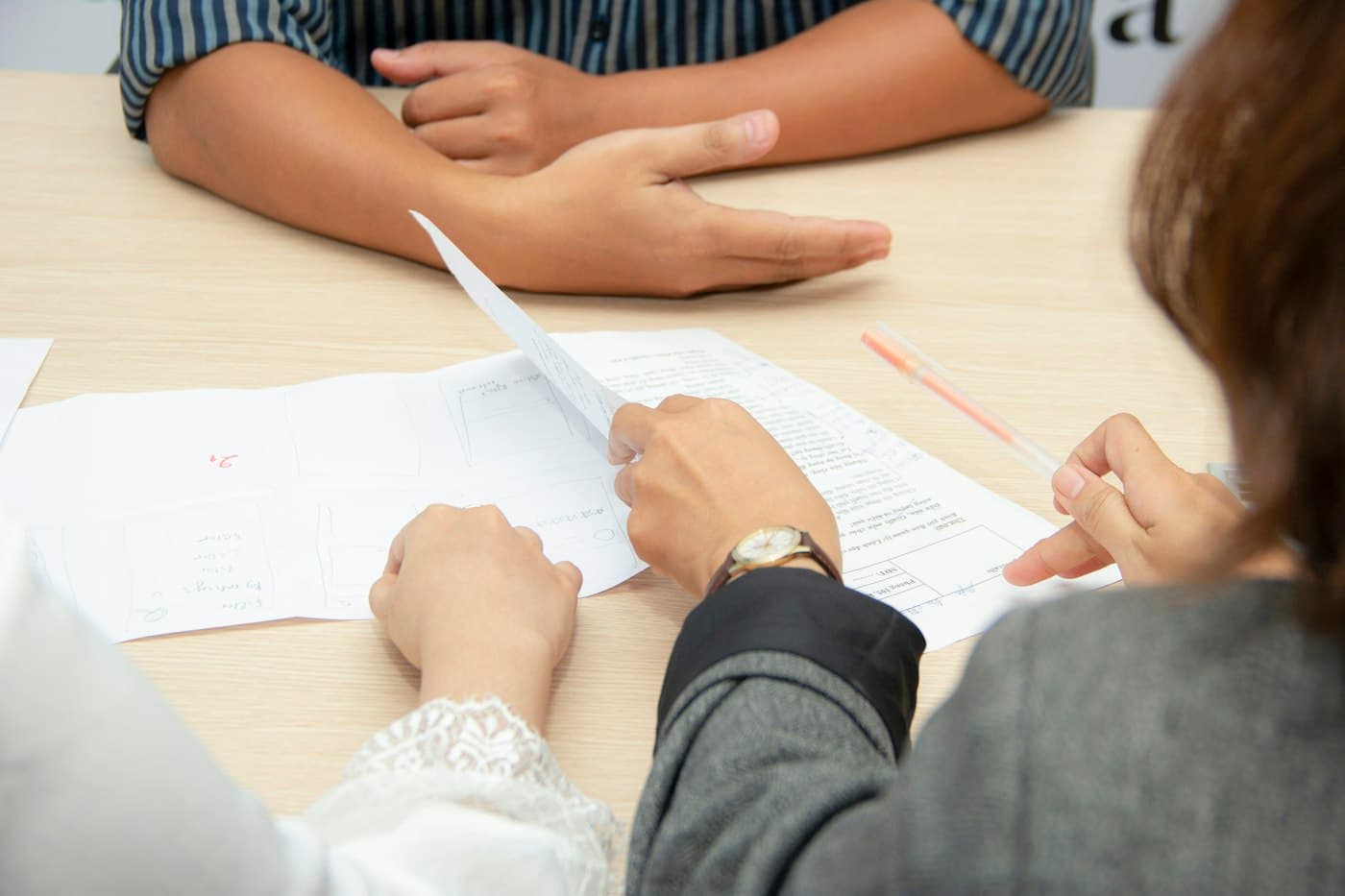 Two professionals reviewing a document together across a table