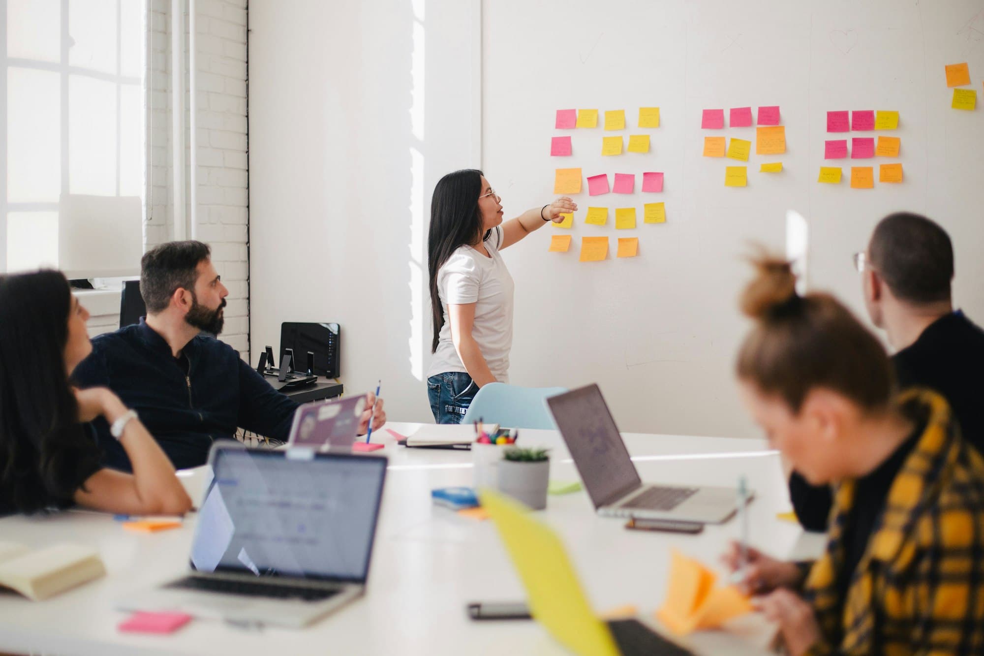 A small team reviewing a project plan on a whiteboard during a working session
